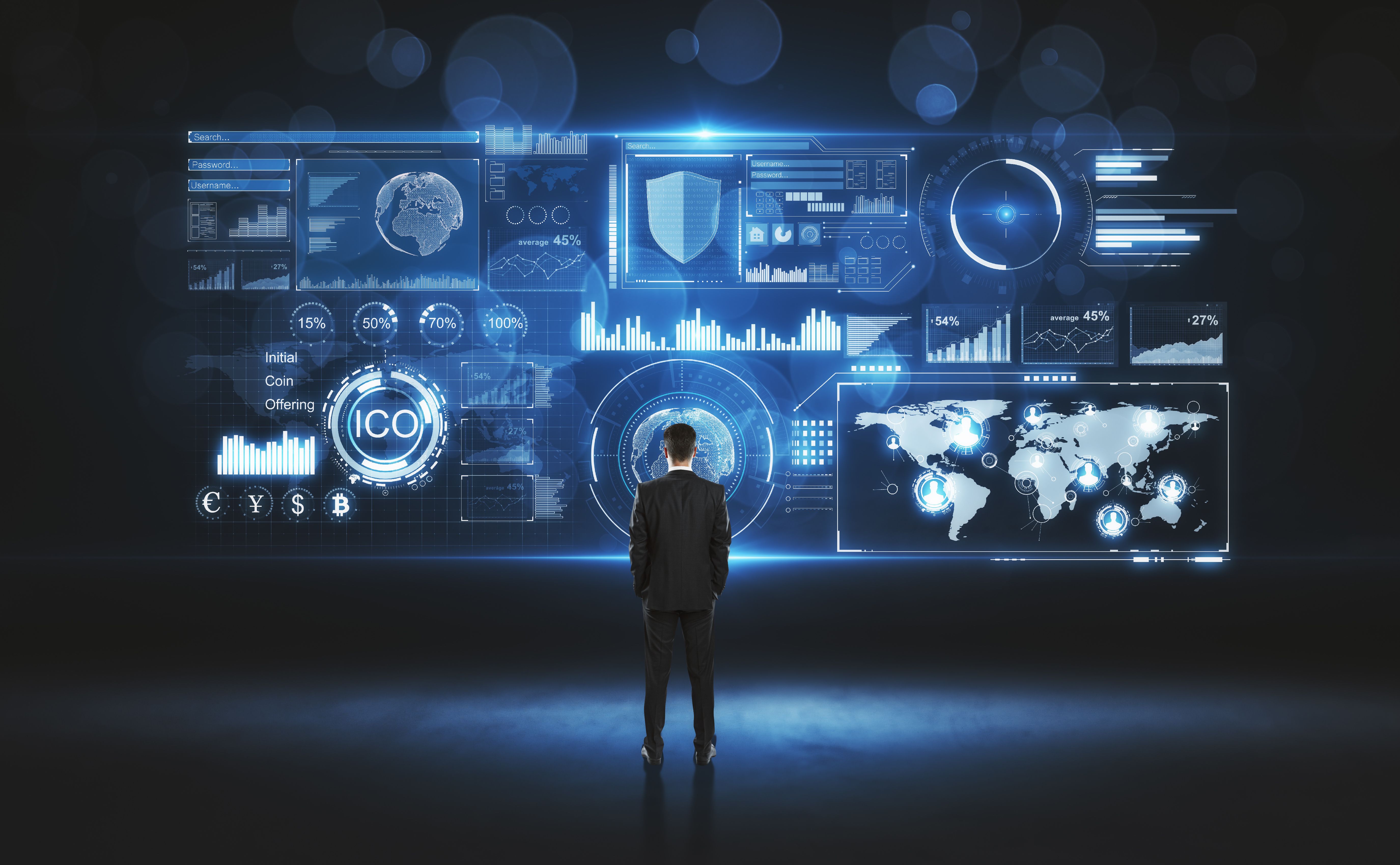 Man standing in front of a large screen displaying cyber security related graphics