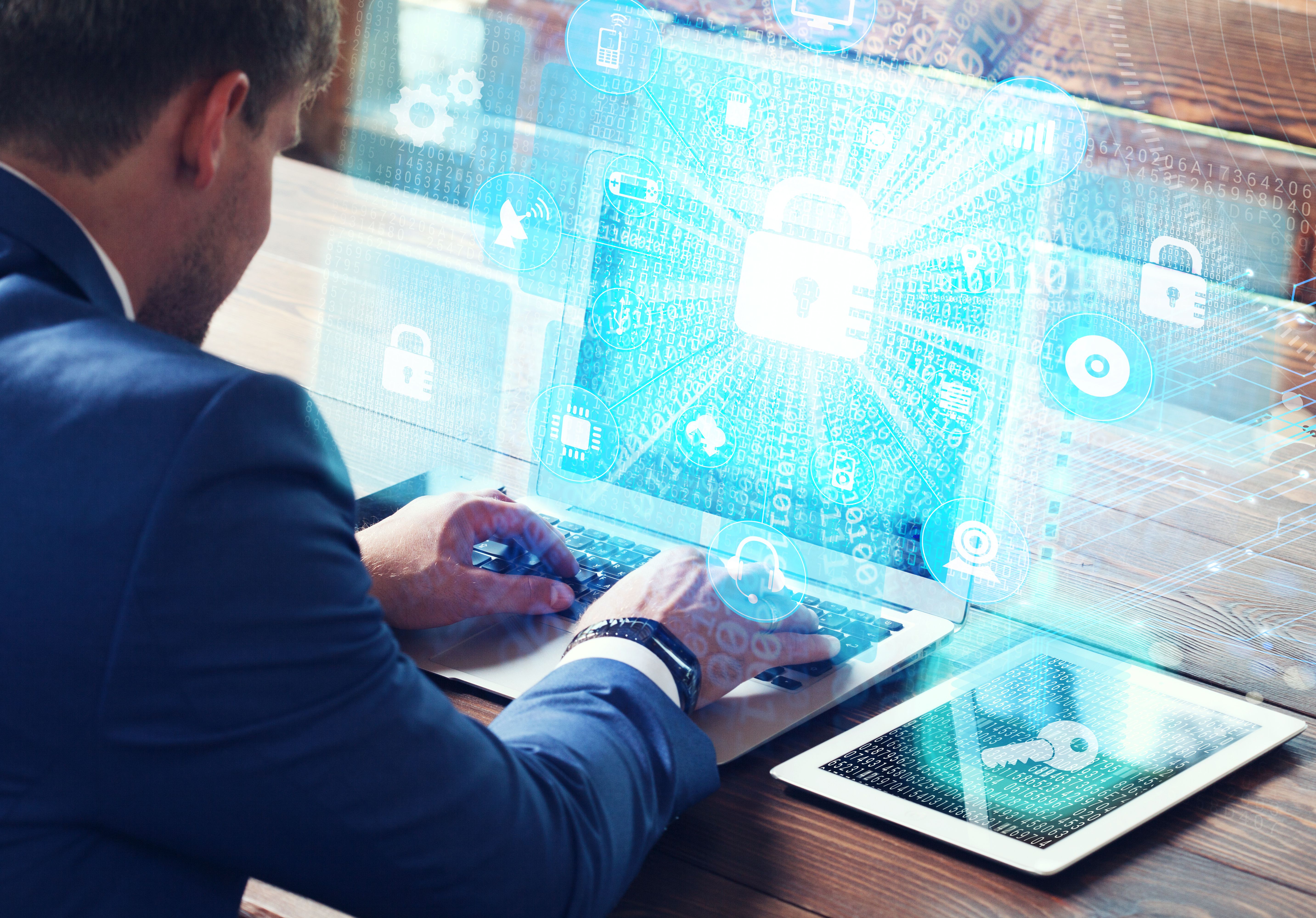 Man typing on a laptop displaying a padlock icon and digital back representing cyber security
