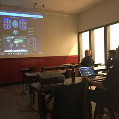 People looking at radar console projected on a wall